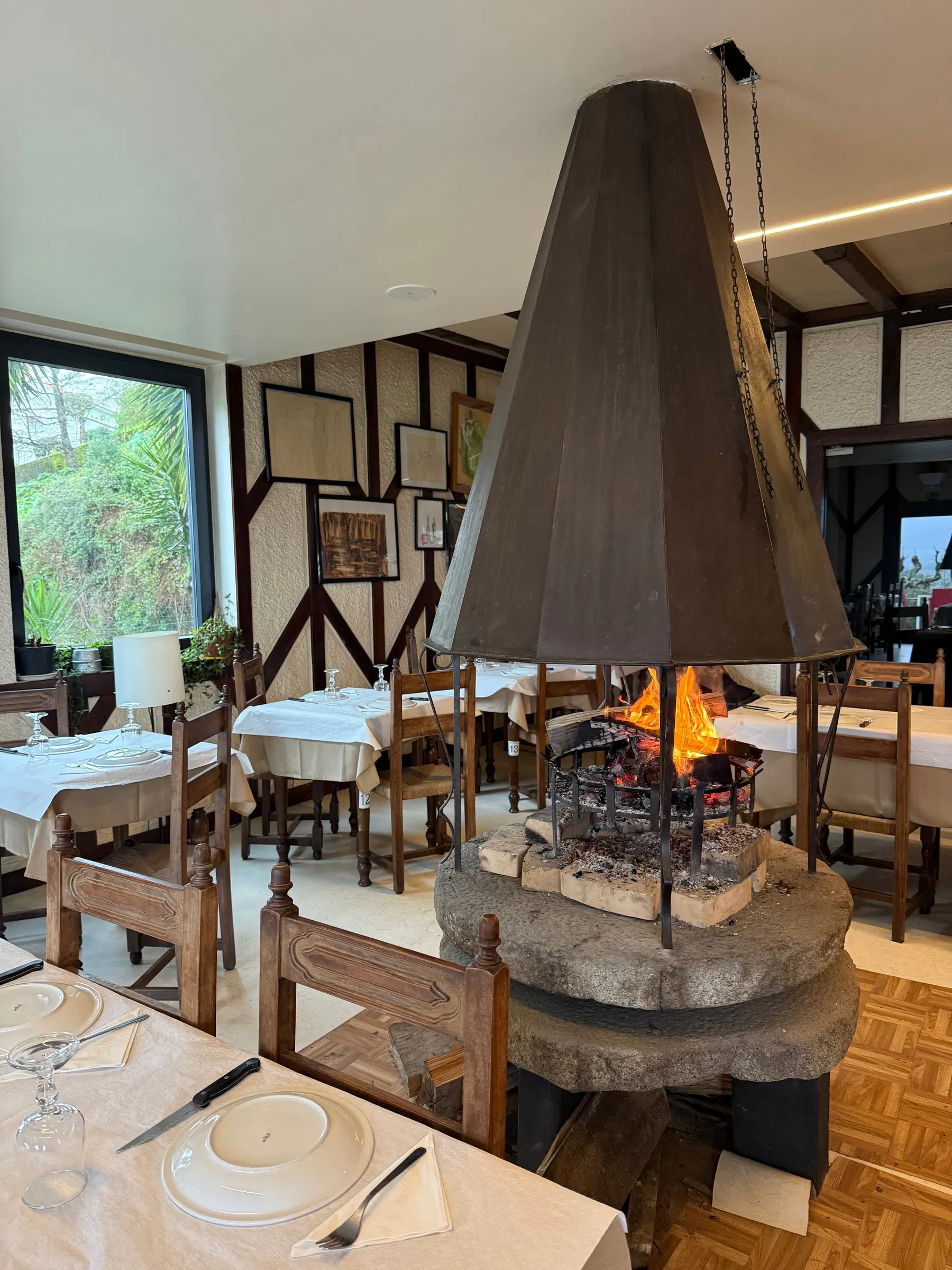 O forno a lenha da Pizzaria Toni, em Loivo, com a mesa posta por baixo da coifa de pedra.
