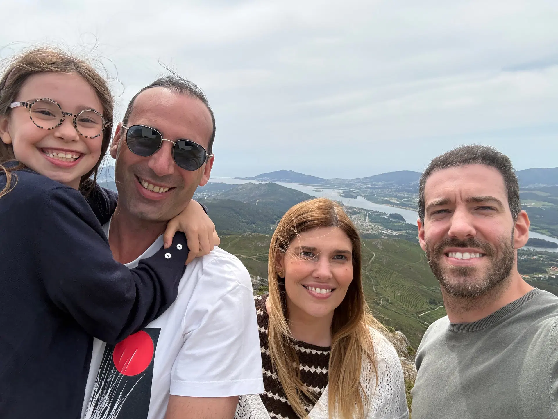 Familia al aire libre, con un río y montañas al fondo