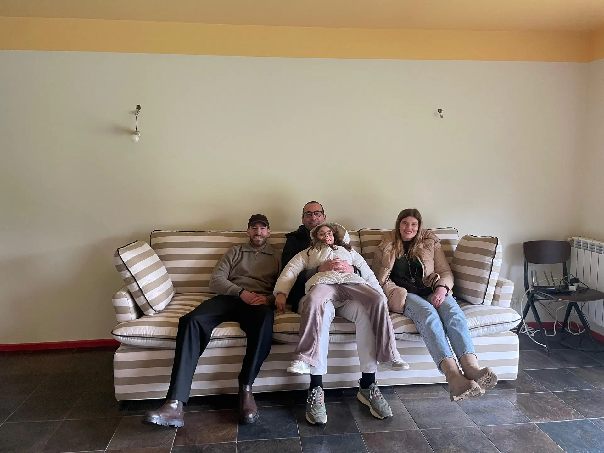 Familia sentada en un sofá de rayas